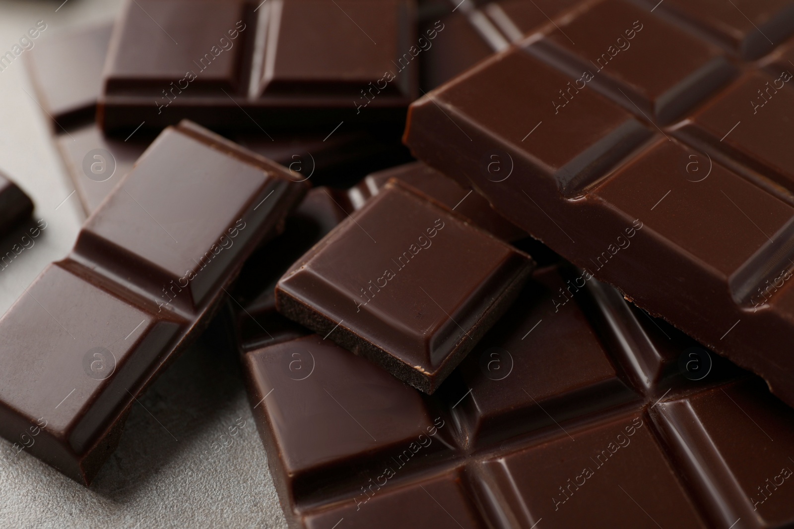 Photo of Delicious dark chocolate on grey table, closeup