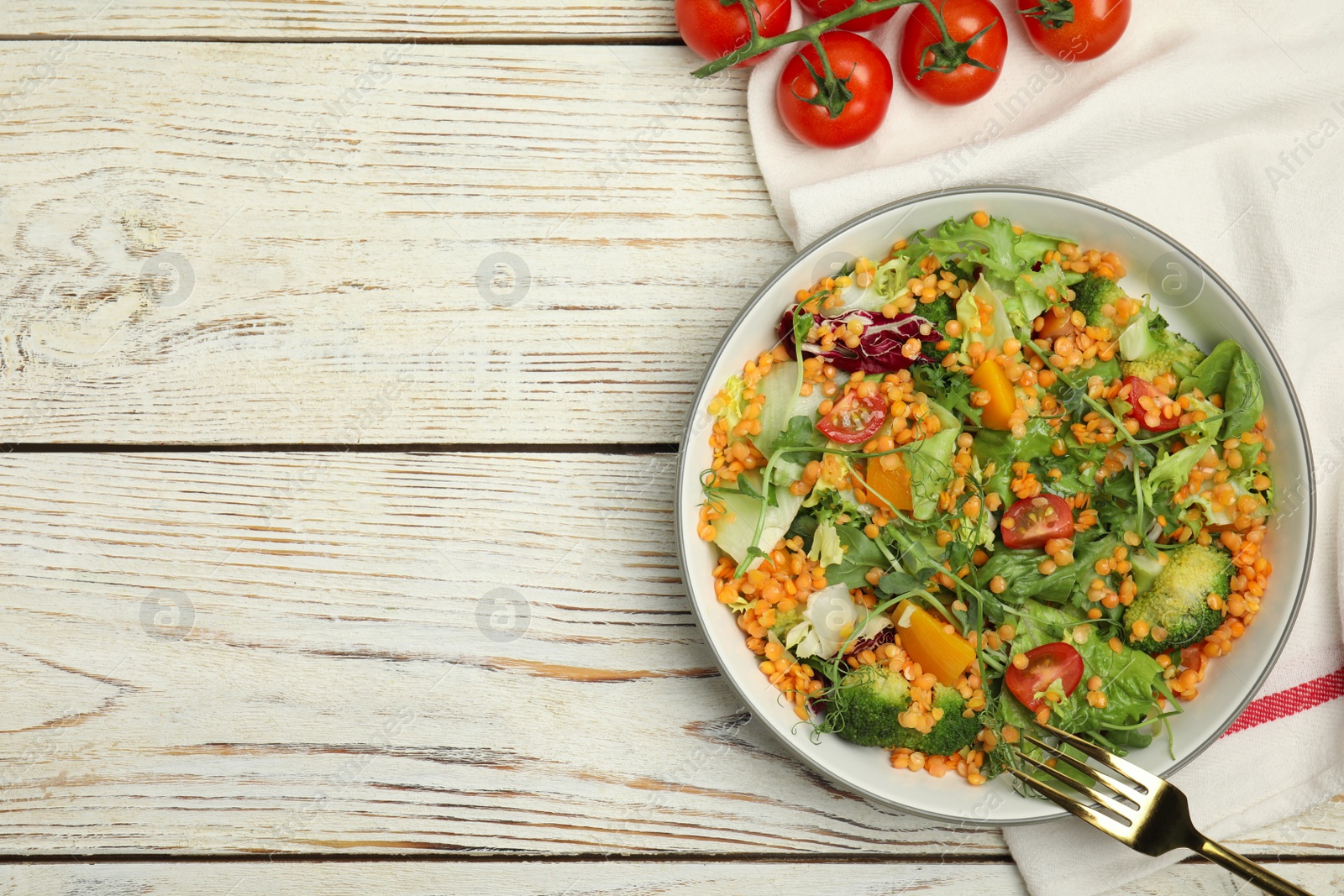 Photo of Delicious salad with lentils and vegetables served on white wooden table, flat lay. Space for text