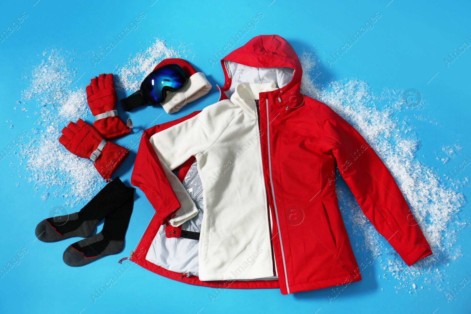 Photo of Stylish winter sport clothes on light blue background, flat lay