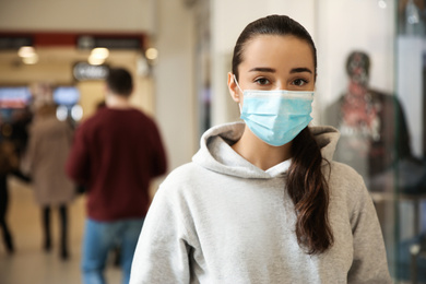 Photo of Woman wearing disposable mask indoors. Dangerous virus