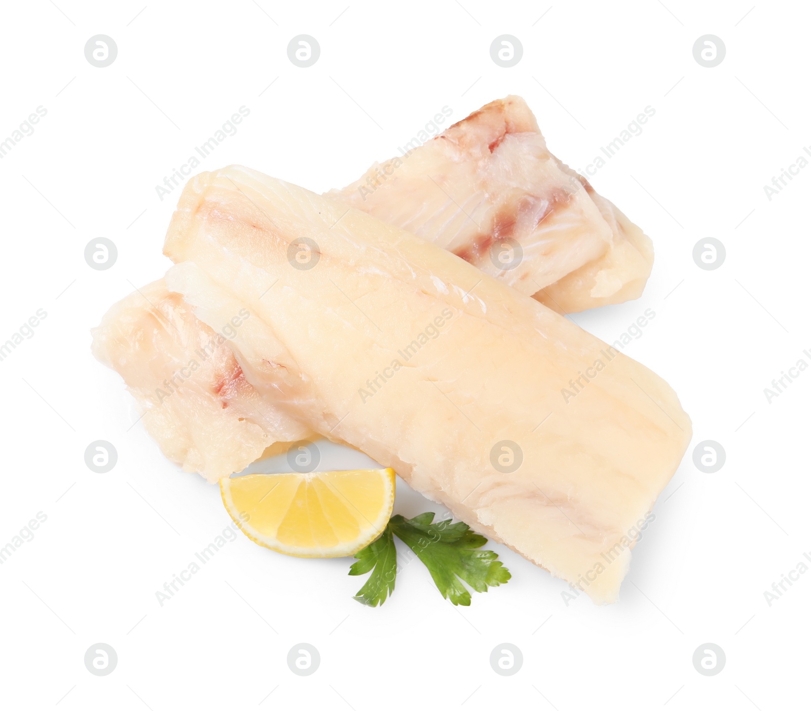Photo of Pieces of raw cod fish, parsley and lemon isolated on white