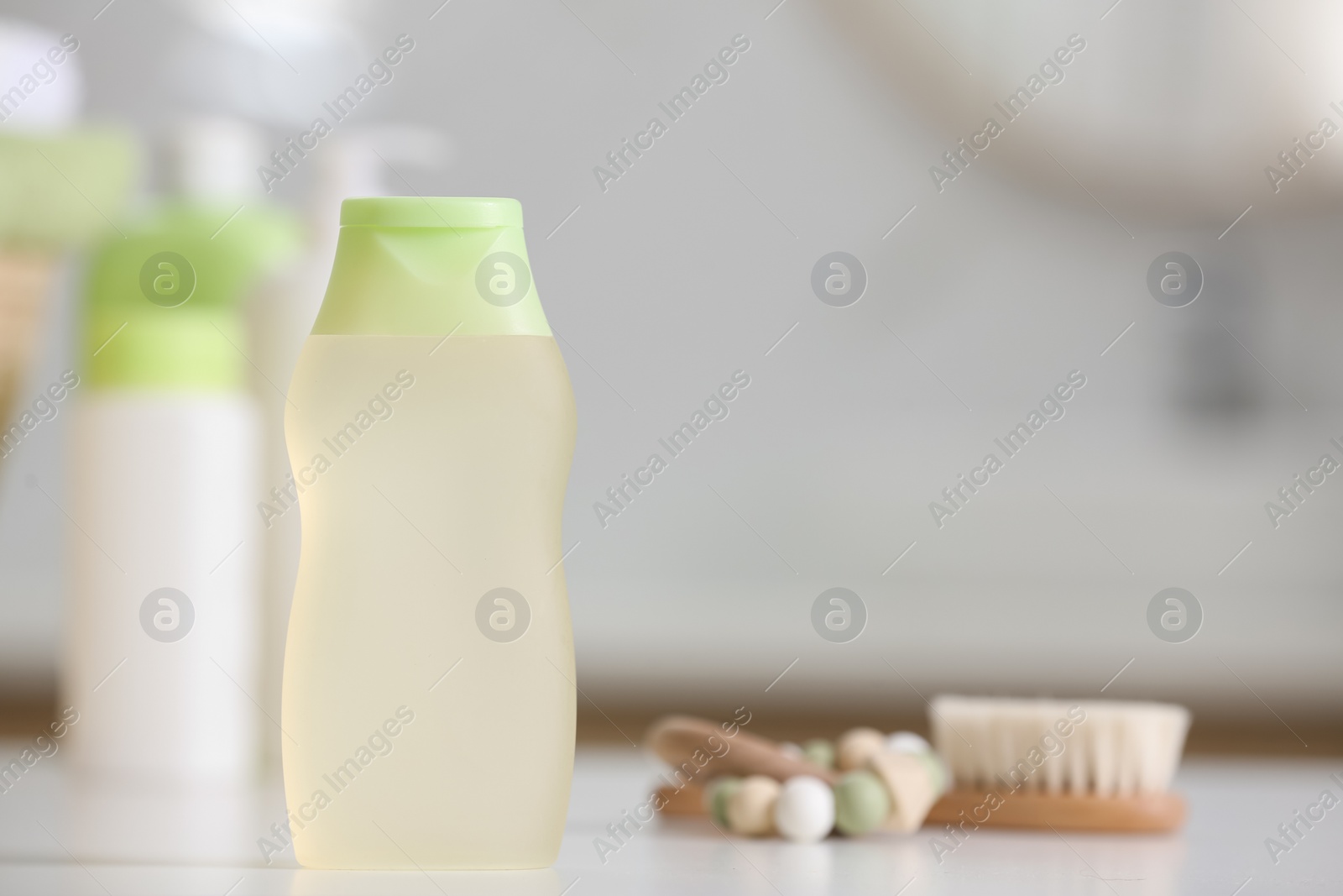 Photo of Bottle of baby cosmetic product on white table, space for text