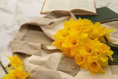 Photo of Bouquet of beautiful daffodils on shirt, closeup