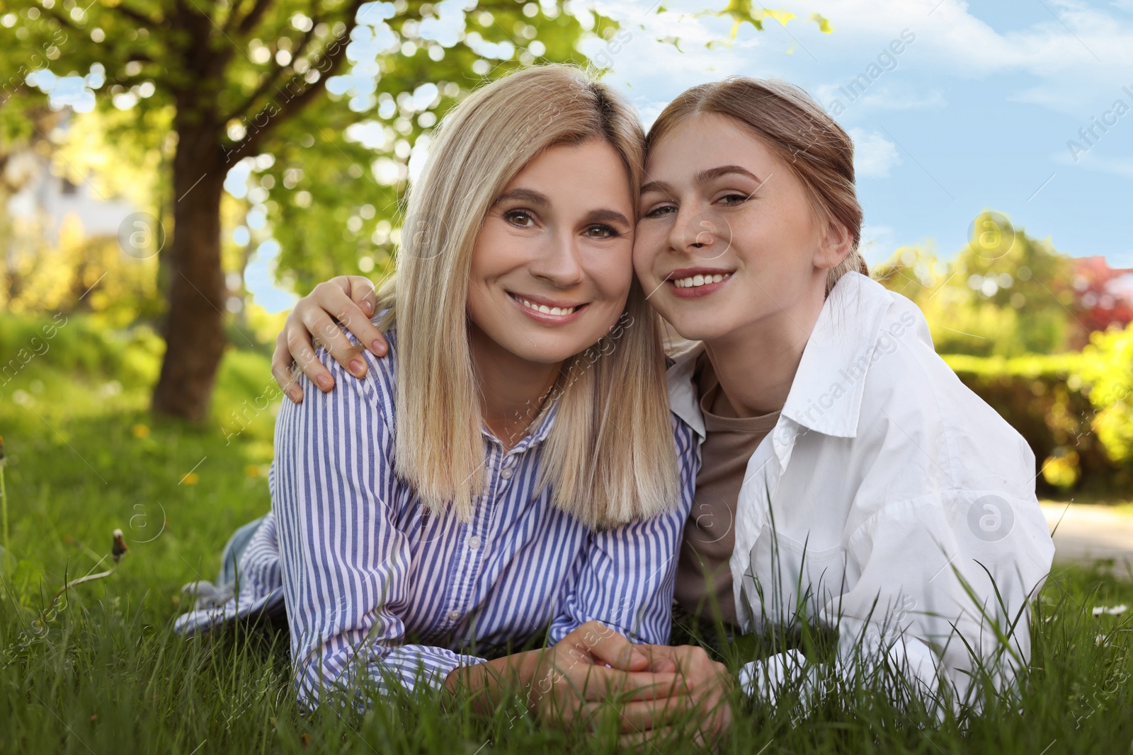 Photo of Happy mother with her daughter on green grass in park