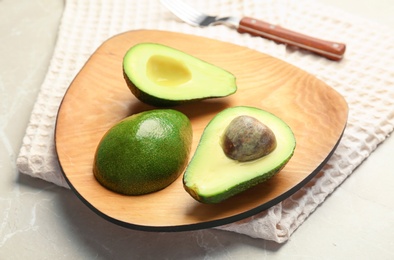 Photo of Wooden board with ripe avocados on table