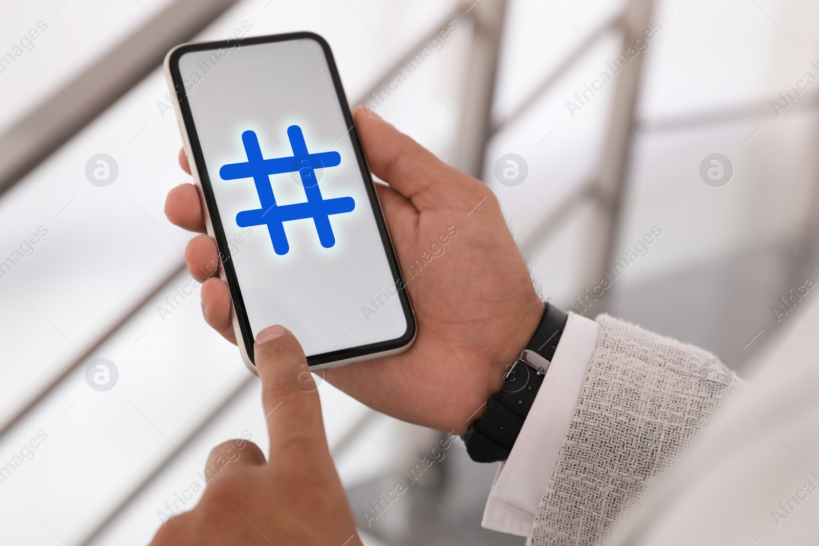 Image of Man using modern smartphone with hashtag symbol on screen, closeup