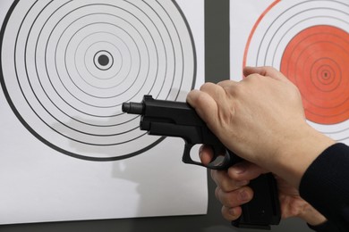 Photo of Man with handgun near shooting target, closeup