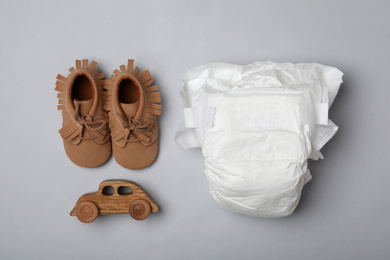 Photo of Diaper and baby accessories on light grey background, flat lay