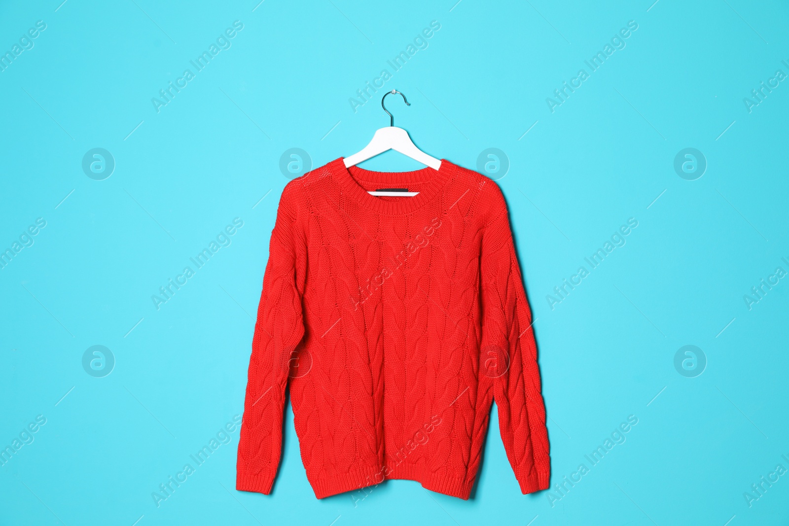 Photo of Hanger with stylish sweater on color background