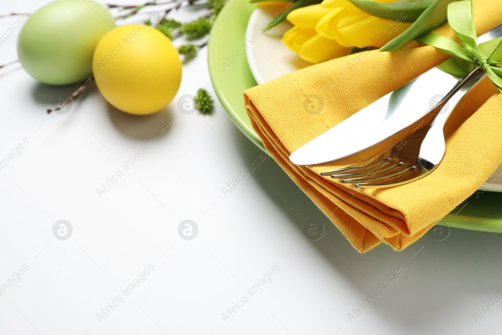 Photo of Festive Easter table setting with floral decor on white background, closeup