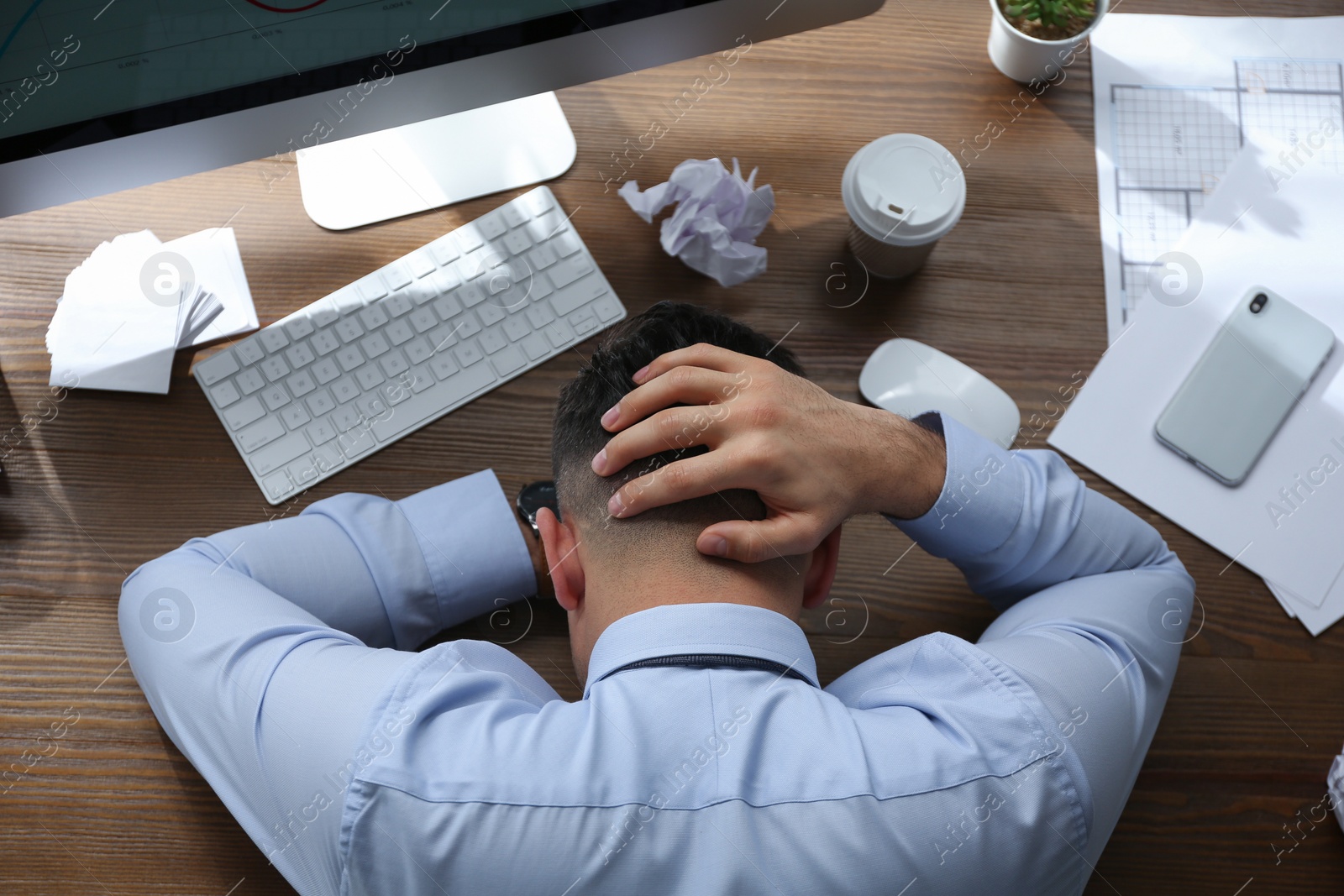 Photo of Stressed out businessman at workplace in office, top view