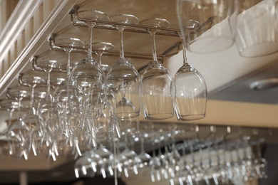 Set of empty clean glasses on bar racks