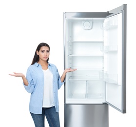 Photo of Emotional woman near empty refrigerator on white background