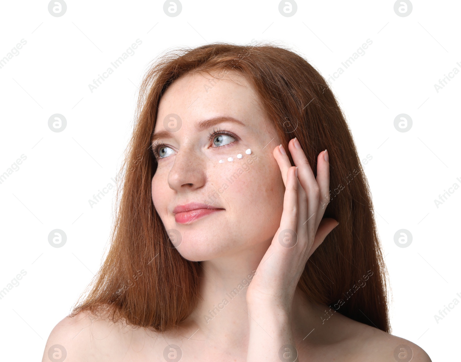 Photo of Beautiful woman with freckles and cream on her face against white background