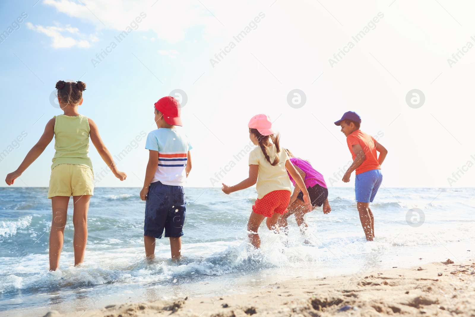 Photo of Cute children enjoying sunny day at beach. Summer camp