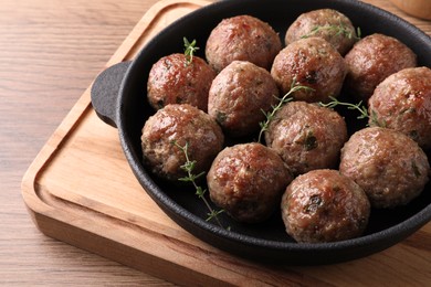 Tasty cooked meatballs served on wooden board