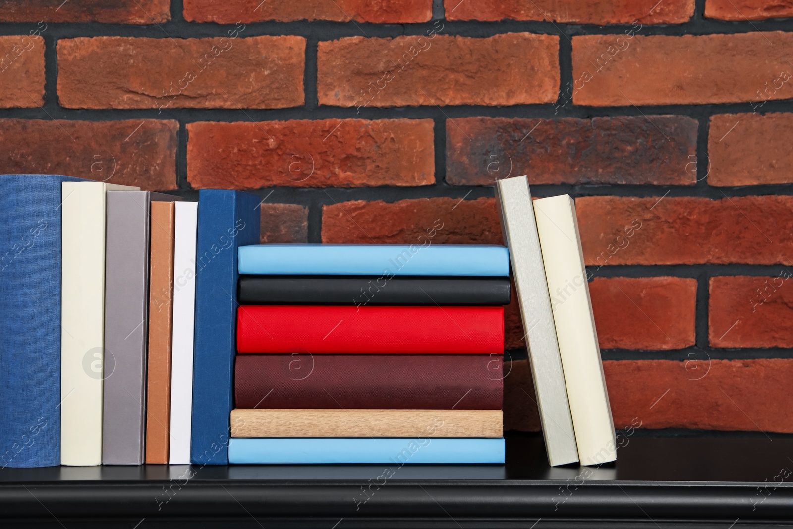 Photo of Many different hardcover books on black console table