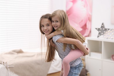 Photo of Cute little sisters having fun together at home