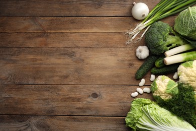 Photo of Different fresh ripe vegetables on wooden table, flat lay. Space for text