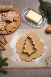 Making Christmas cookies. Flat lay composition with ingredients and raw dough on grey table