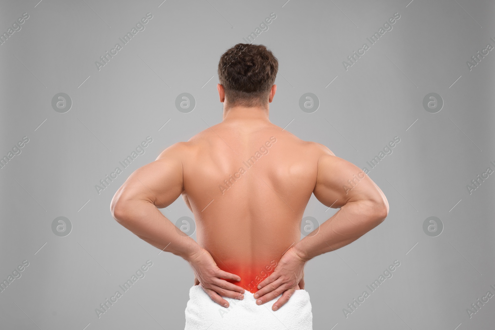 Image of Man suffering from pain in lower back on grey background