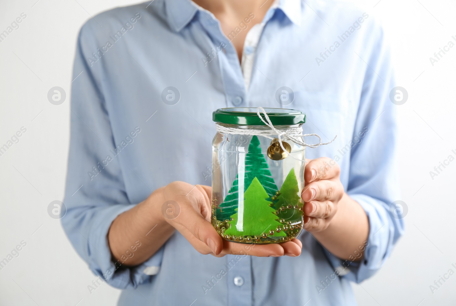 Photo of Woman holding handmade snow globe on white background, closeup