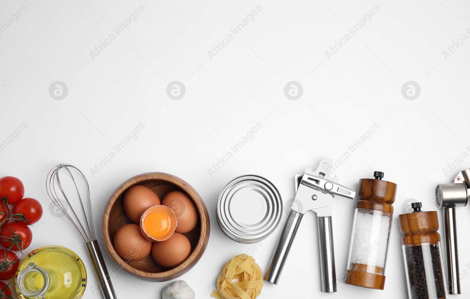 Photo of Cooking utensils and ingredients on white background, top view