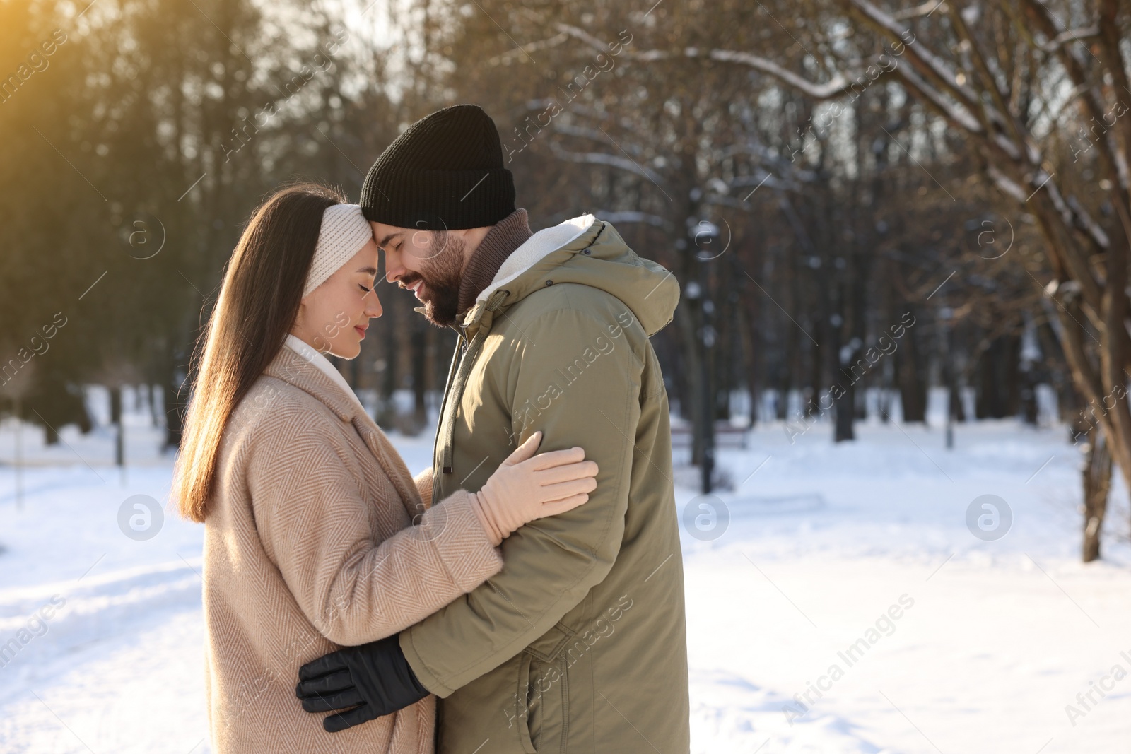 Photo of Beautiful happy couple in snowy park on winter day