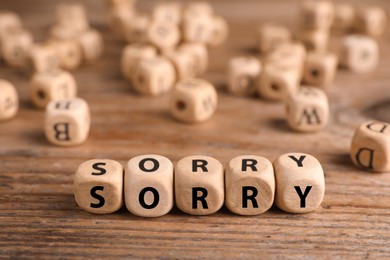 Image of Apology. Word Sorry made of cubes on wooden table