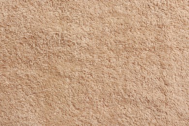 Photo of Soft beige towel as background, top view