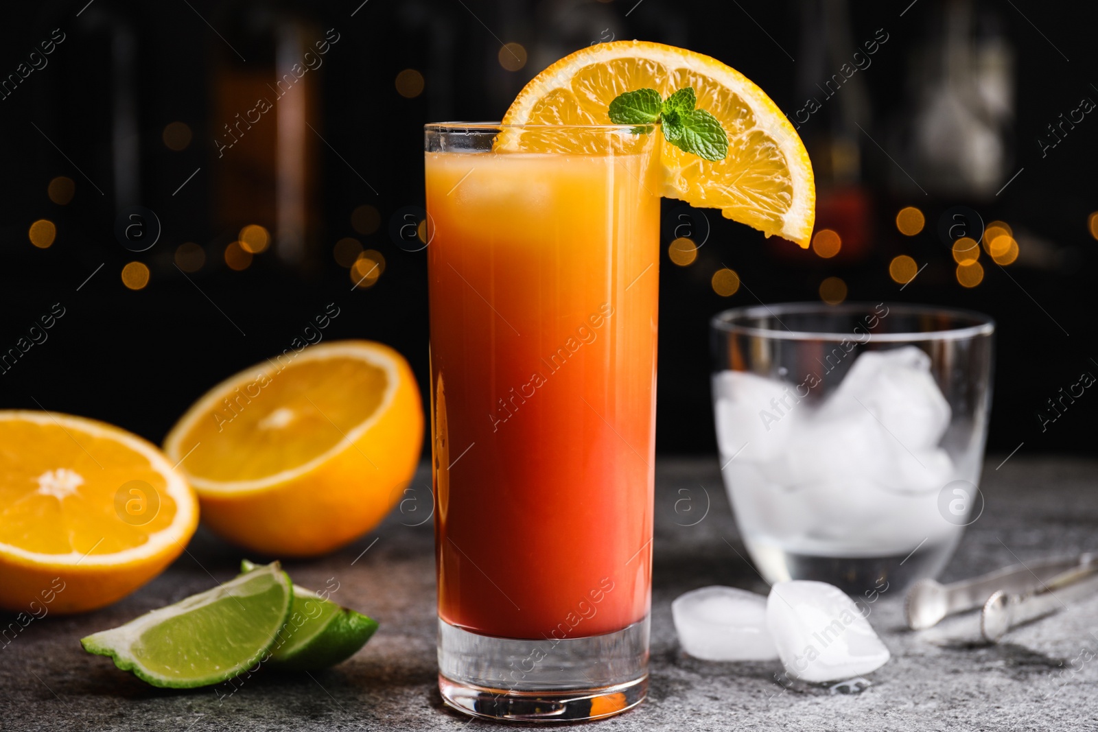 Photo of Fresh alcoholic Tequila Sunrise cocktail on grey table