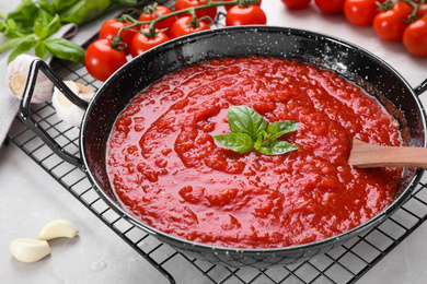 Photo of Delicious tomato sauce in pan on table, closeup