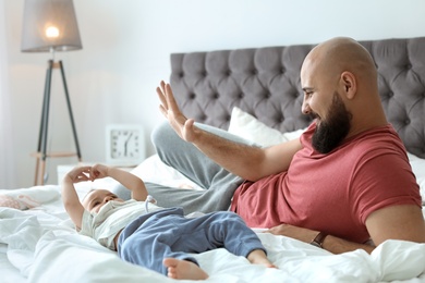 Photo of Dad and his little son spending time together at home