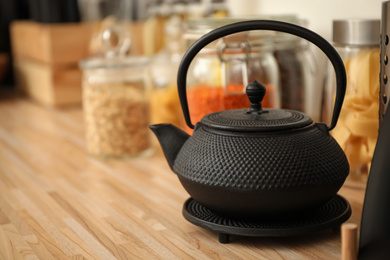 Photo of Black teapot on wooden countertop in kitchen. Interior element