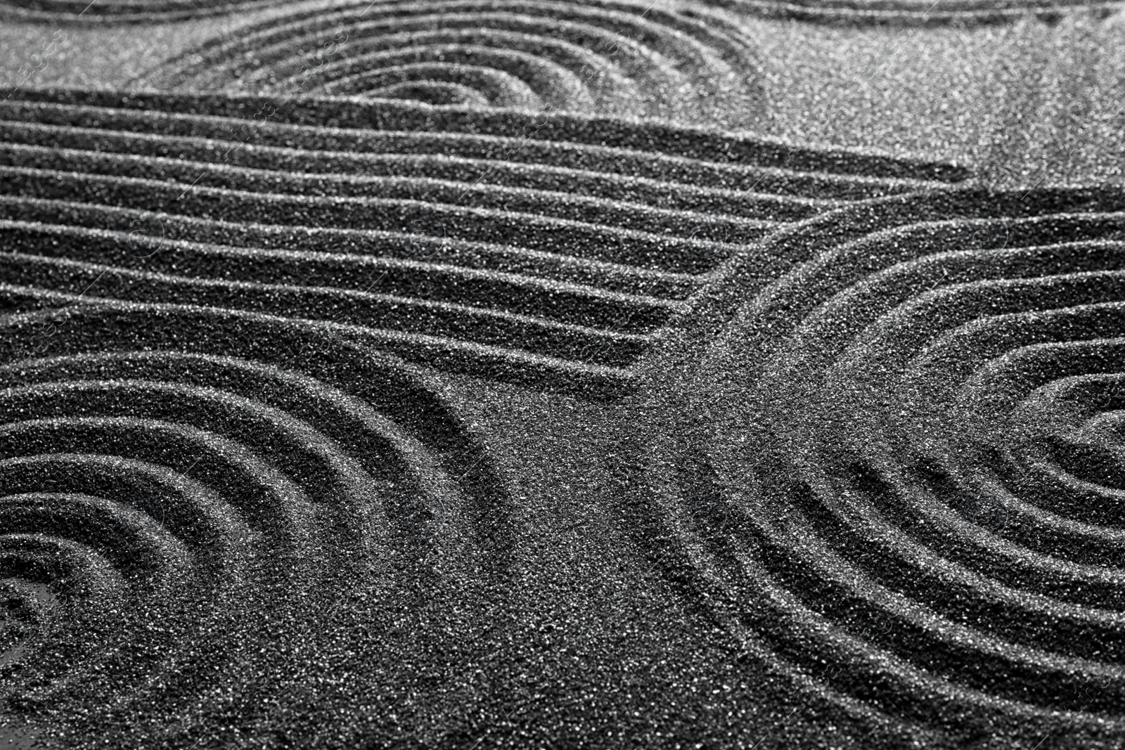 Photo of Pattern on decorative black sand, closeup. Zen and harmony