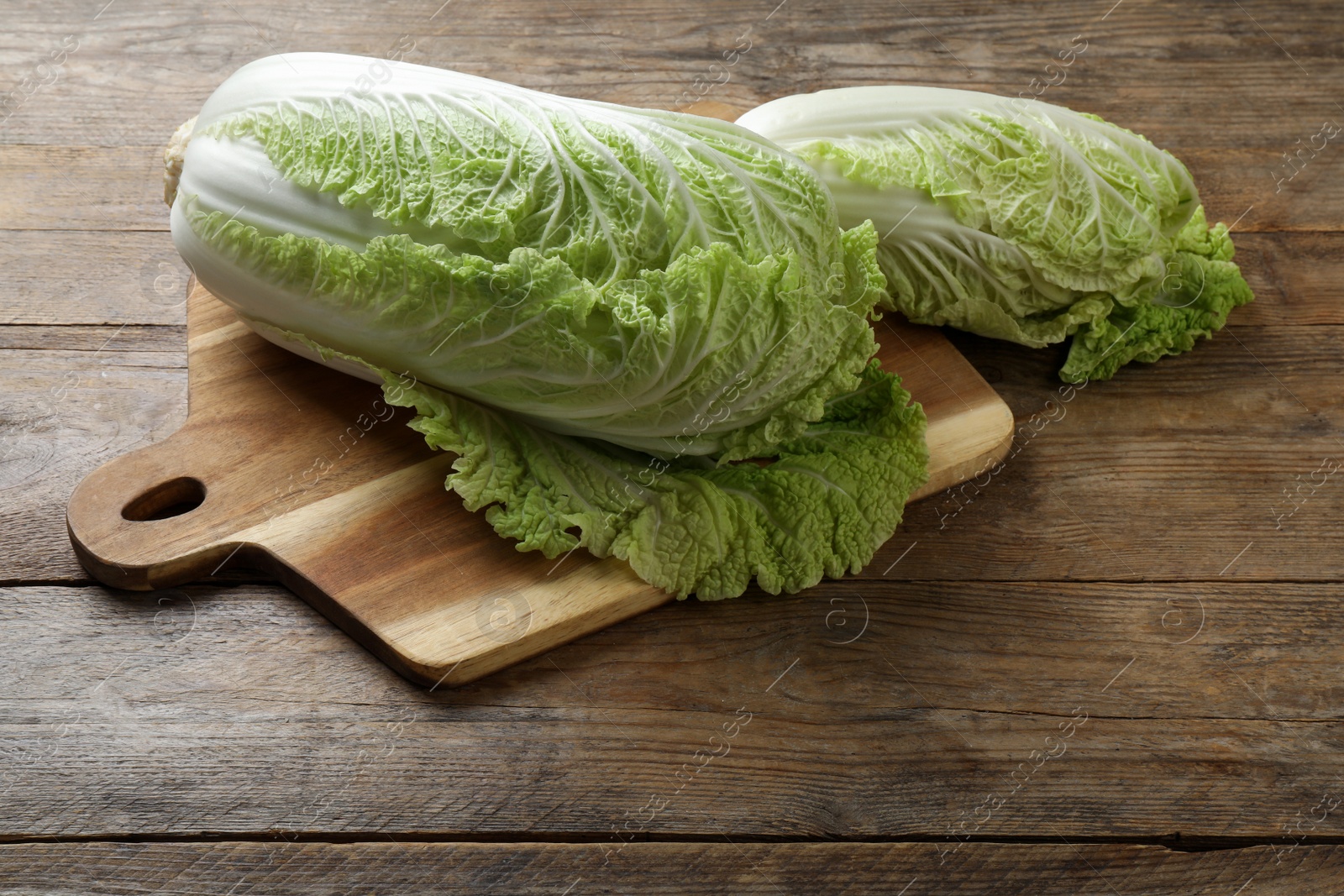 Photo of Fresh ripe Chinese cabbages on wooden table