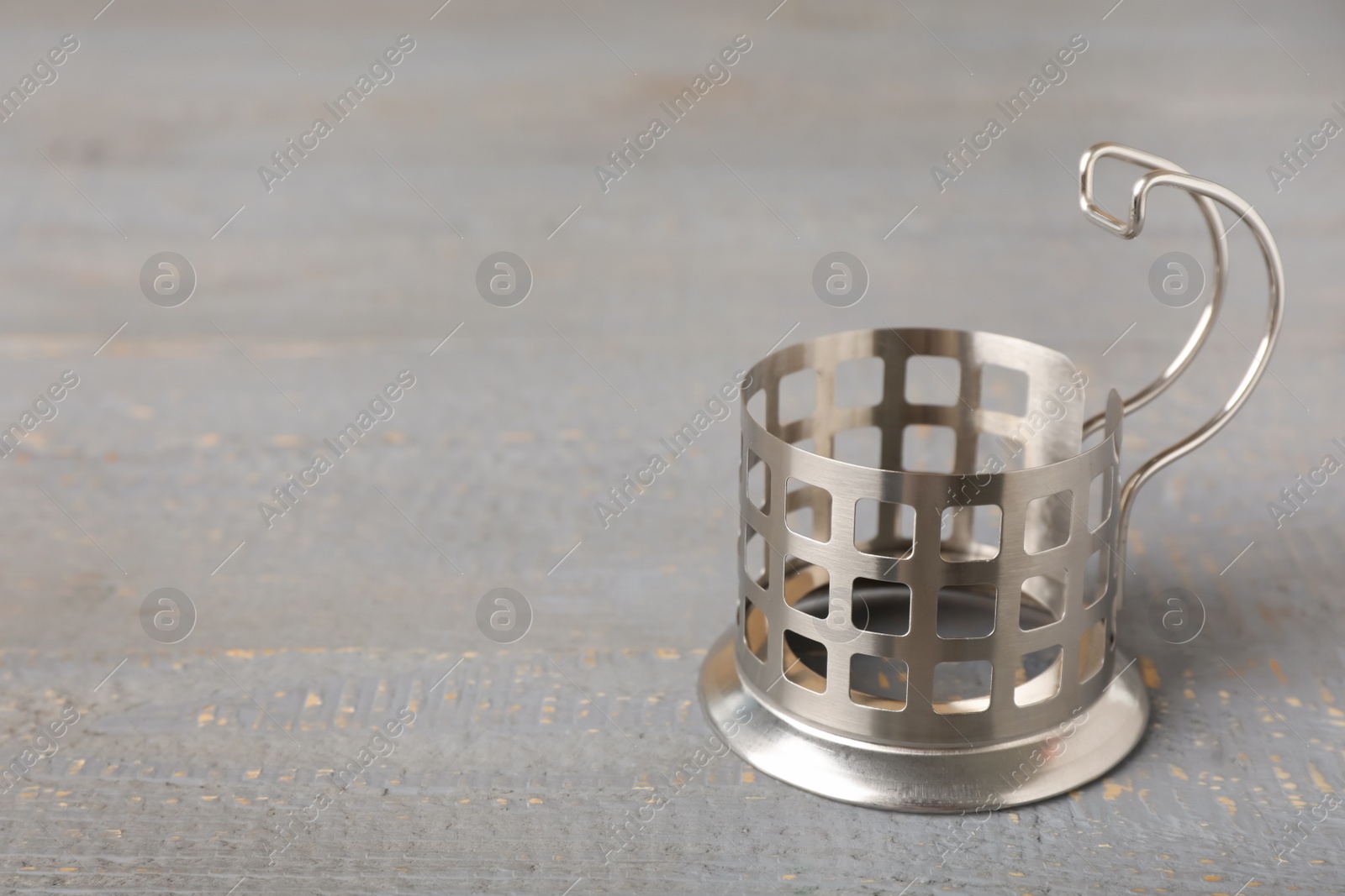 Photo of Traditional tea glass holder on grey wooden table, space for text