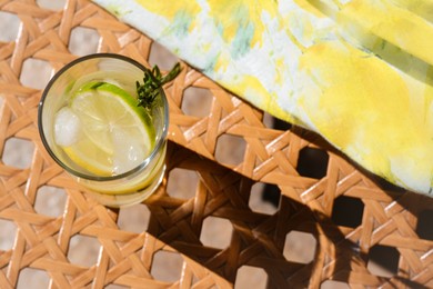 Photo of Summer refreshing lemonade on wicker bench, above view. Space for text