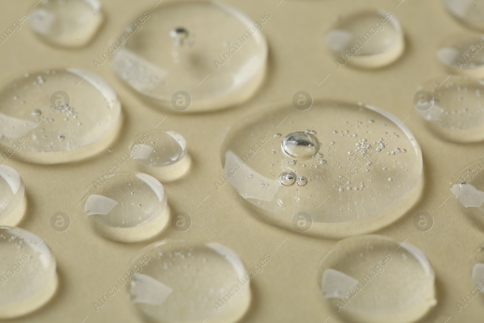 Photo of Samples of cosmetic serum on beige background, closeup