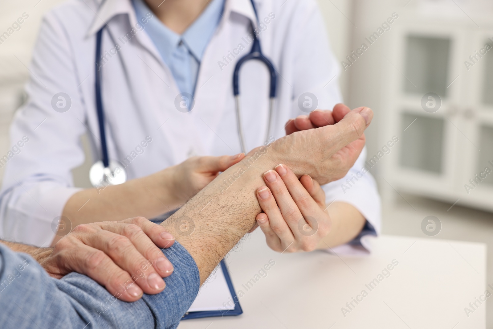 Photo of Arthritis symptoms. Doctor examining patient's wrist in hospital, closeup