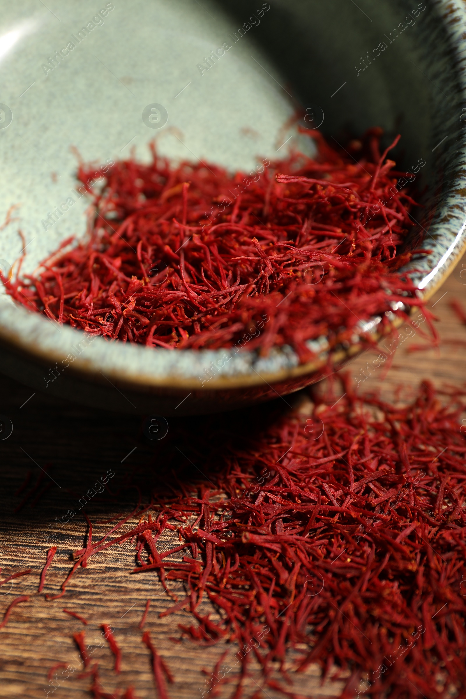 Photo of Aromatic saffron in bowl on table, closeup