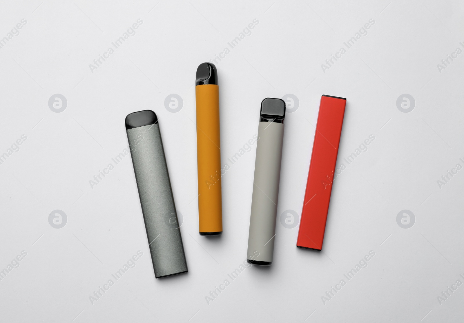 Photo of Different electronic cigarettes on white background, top view