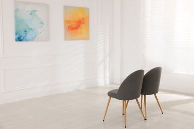 Photo of Chairs and beautiful paintings in art gallery