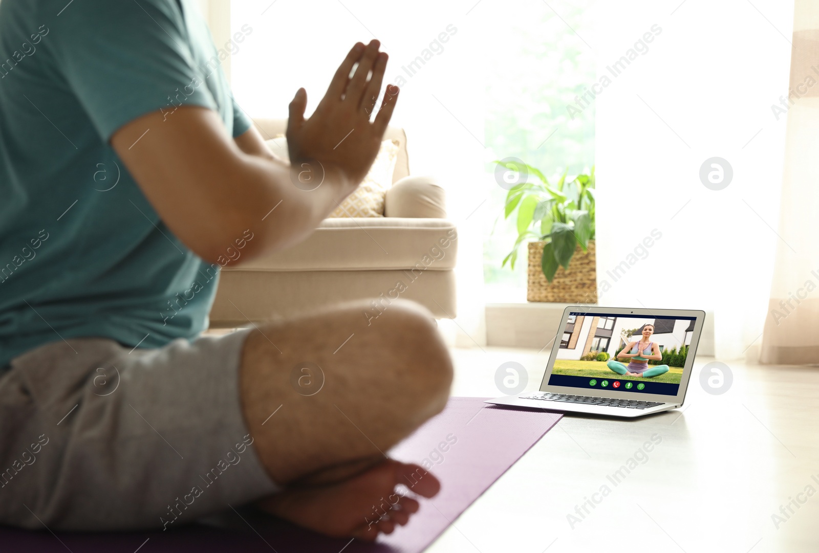 Image of Distance yoga course during coronavirus pandemic. Man having online practice with instructor via laptop at home, closeup