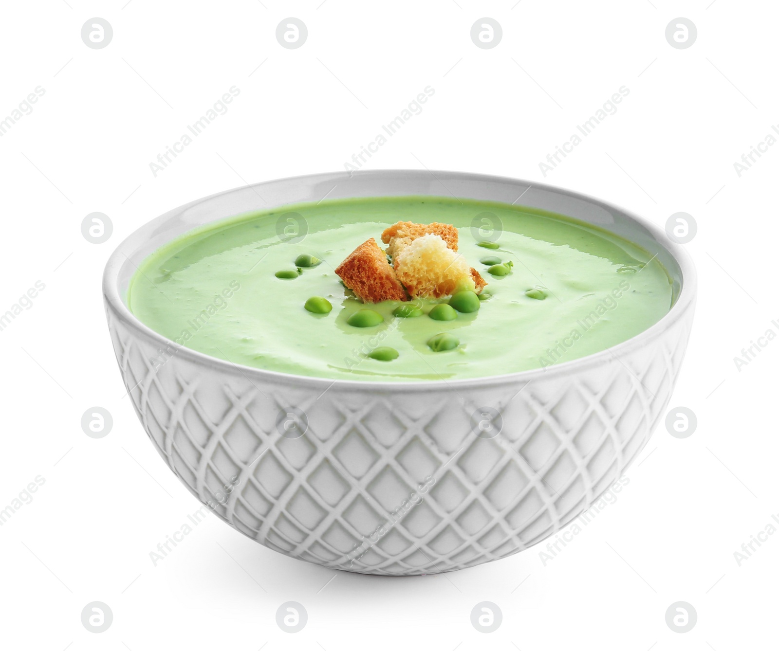 Photo of Green pea soup with croutons in bowl on white background