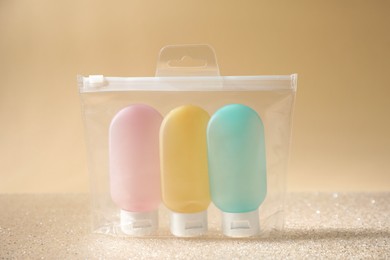 Cosmetic travel kit in plastic bag on beige background. Bath accessories