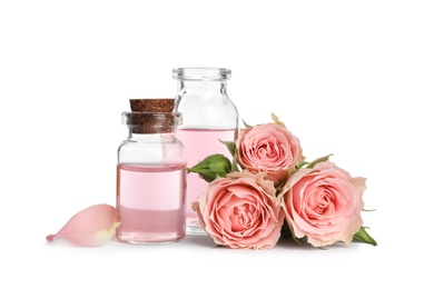 Bottles of rose essential oil and flowers isolated on white