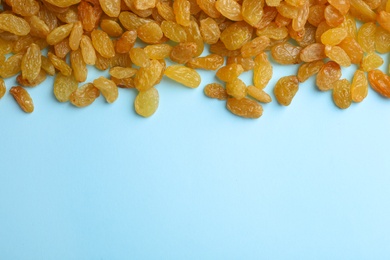 Photo of Many raisins on color background, top view with space for text. Dried fruit as healthy snack