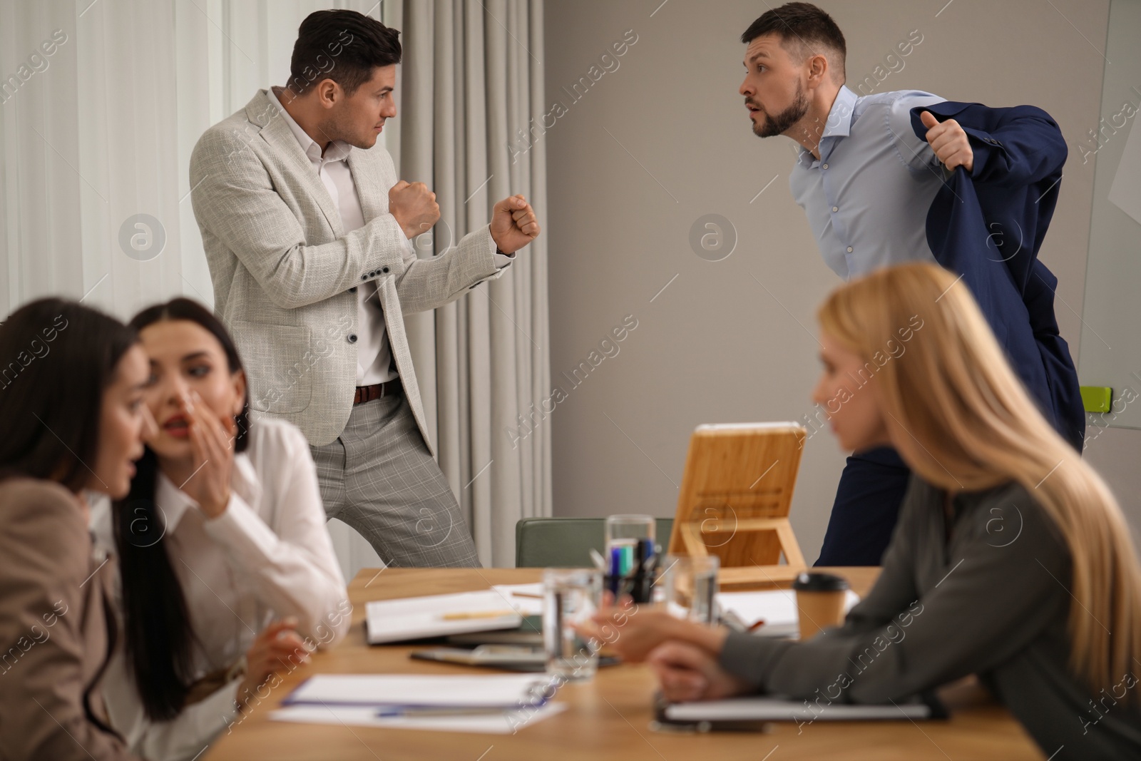 Photo of Angry coworkers quarreling at workplace in office