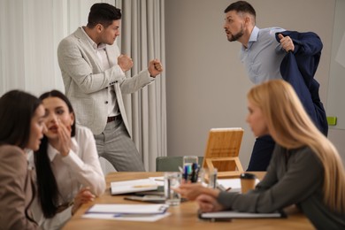 Angry coworkers quarreling at workplace in office
